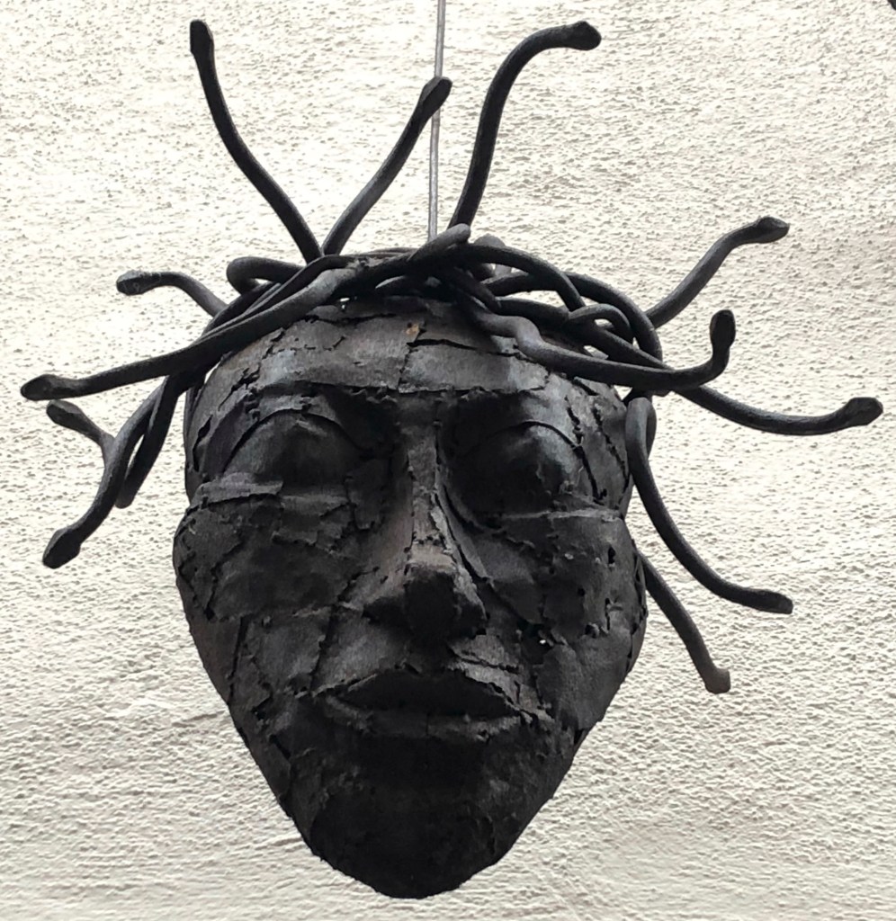 Ein schwarzer Kopf mit Schlangen oder Dreadlocks als Haare. Gefunden in Konstanz über einem Friseurladen. 